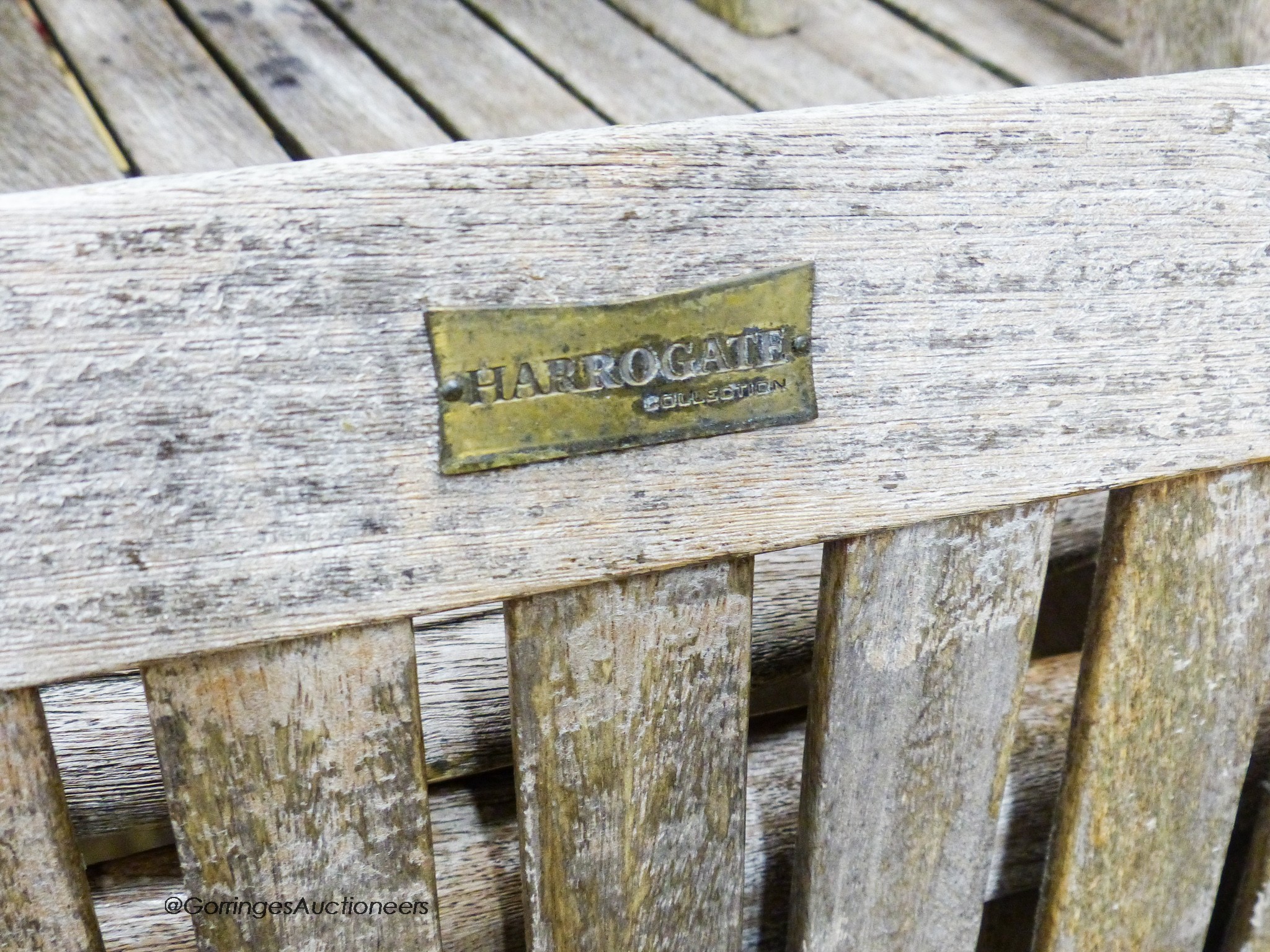 A weathered teak extending garden table, 204cm extended, length 108cm, height 76cm together with six weathered teak folding garden armchairs, stamped Harrogate collection